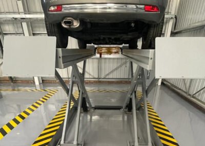An elevated car in a service bay at an mot test centre in northampton, showing fresh resin line marking