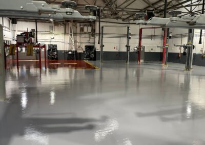 Finished garage workshop floor, using epoxy resin. Red for the majority of the surface and red for the mot bay