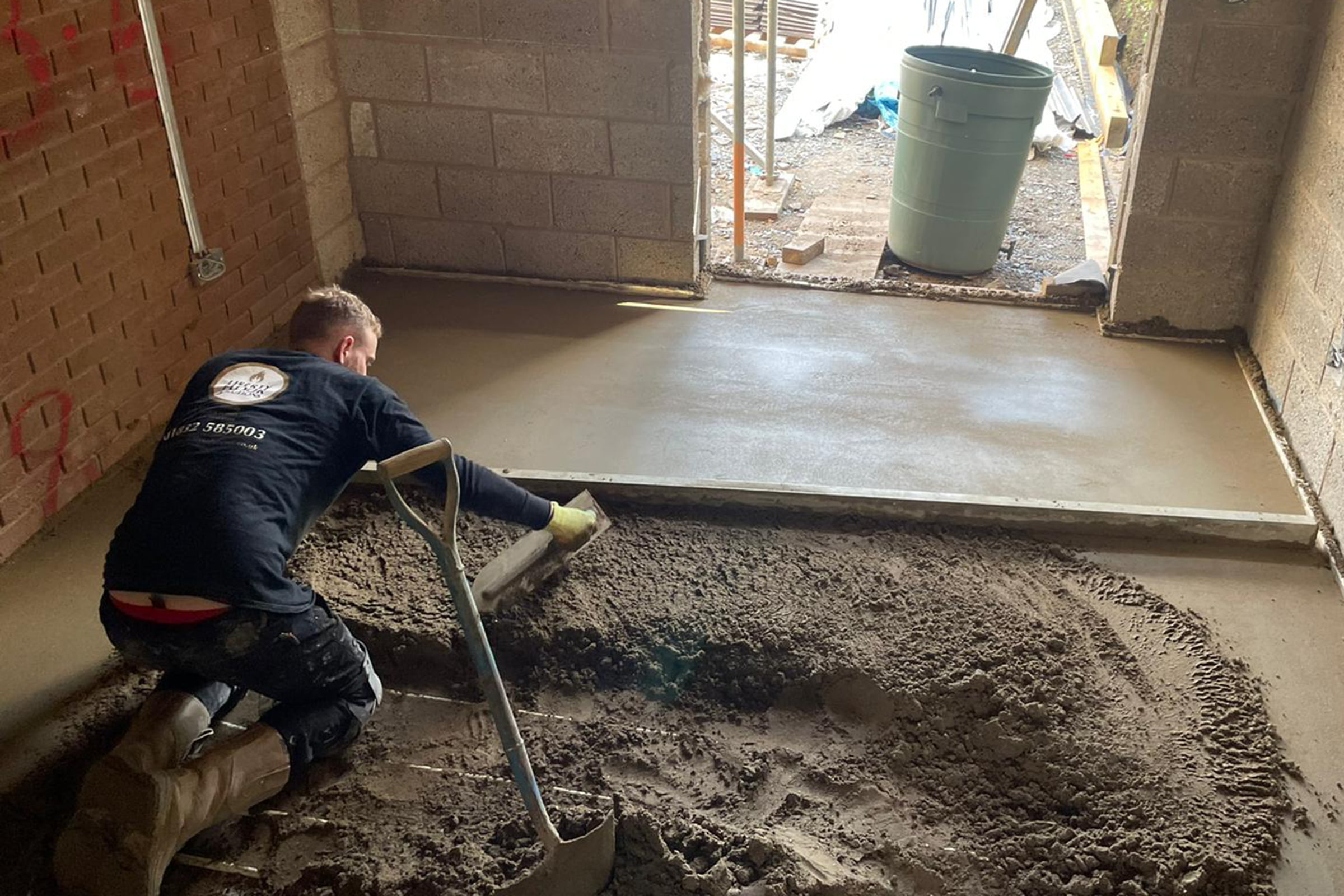 Floor screed contractor working with traditional screed on a house extension project