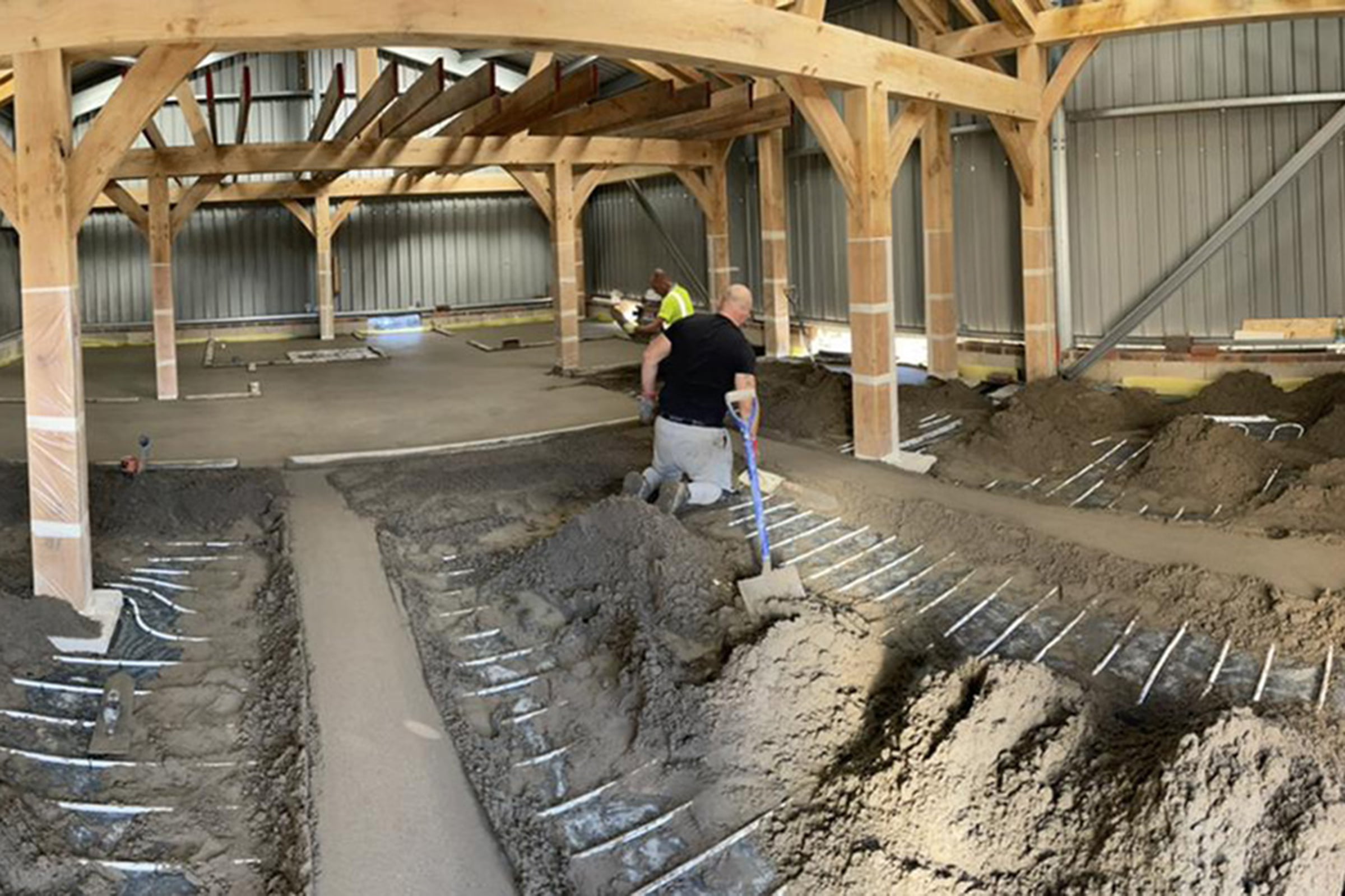 Floor screed contractor at work in an Oak framed building Kent