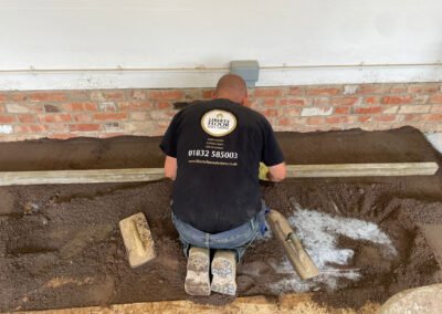 Floor screed contractor carrying out repairs, prior to the installation of resin bound surface