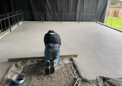 Screeding contractor at work, installing a resin bound stage surface to the stage in hall park rushden