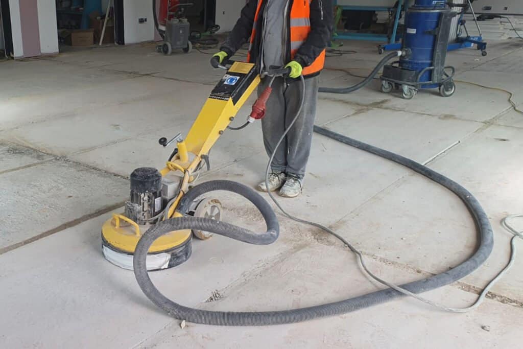 Floor screed contractor using a vacuum assisted diamond concrete grinder