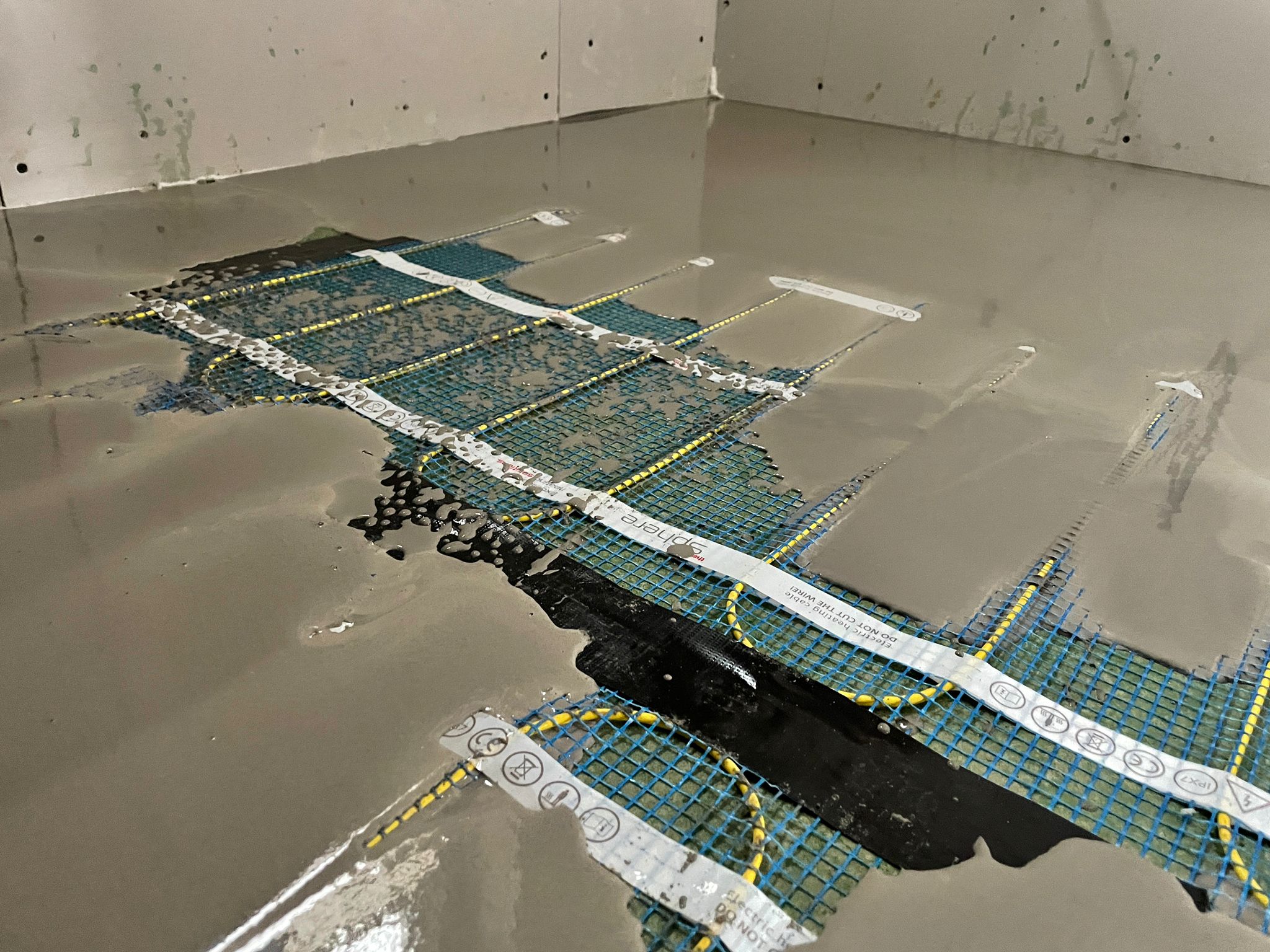 Thermosphere underfloor heating mesh installation Flow screed being installed on Thermosphere underfloor heating mesh