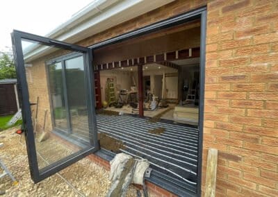 View of underfloor heating installation taken through an open window from the garden