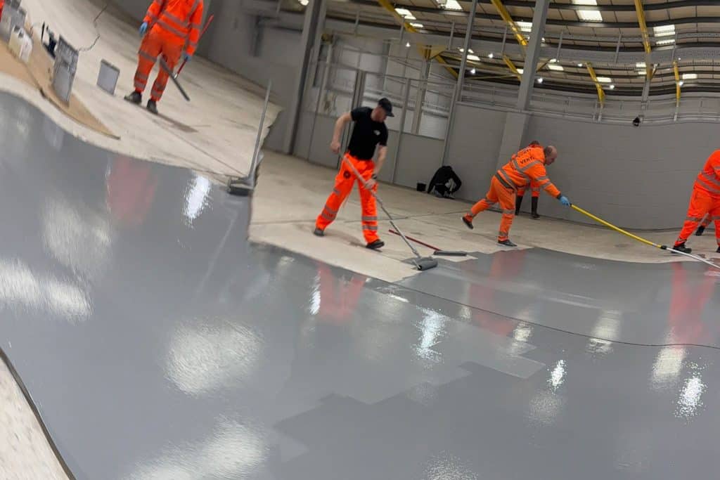 Workers applying resin flooring indoors