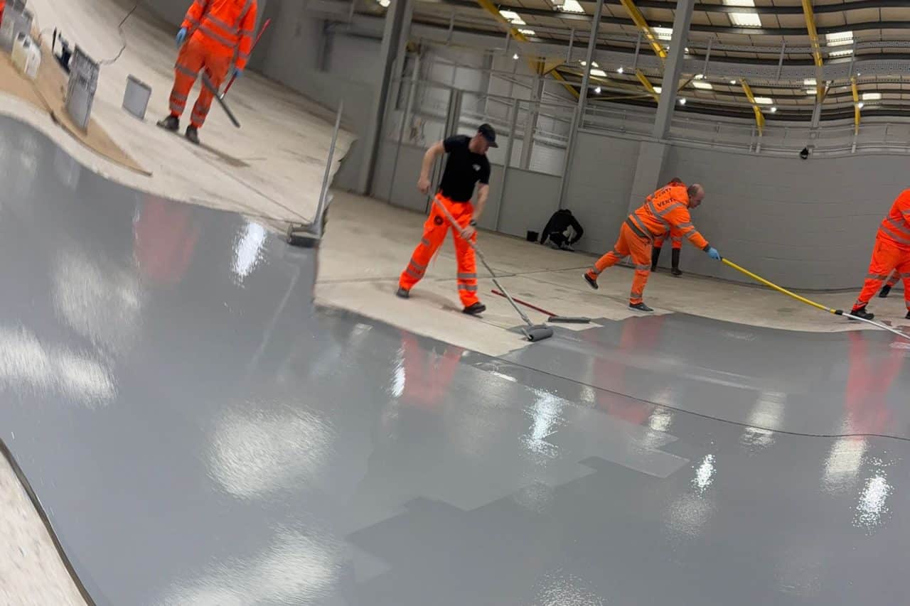 Workers applying resin flooring indoors