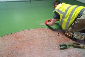 Man applying green flooring material