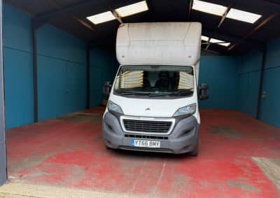 Empty storage space with a van and tatty red resin flooring