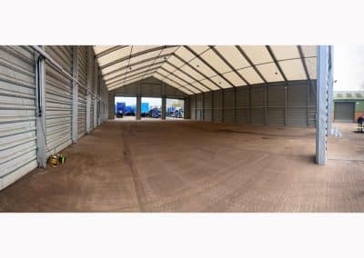 Large empty warehouse with trucks outside