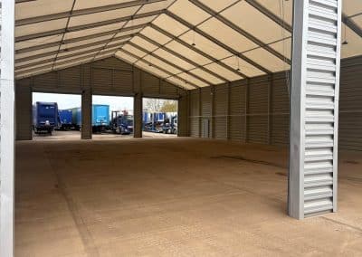 Empty storage area concrete flooring and trucks outside