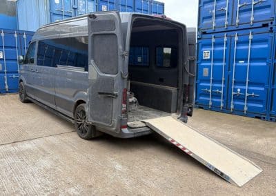 Gray van with open rear doors and a ramp