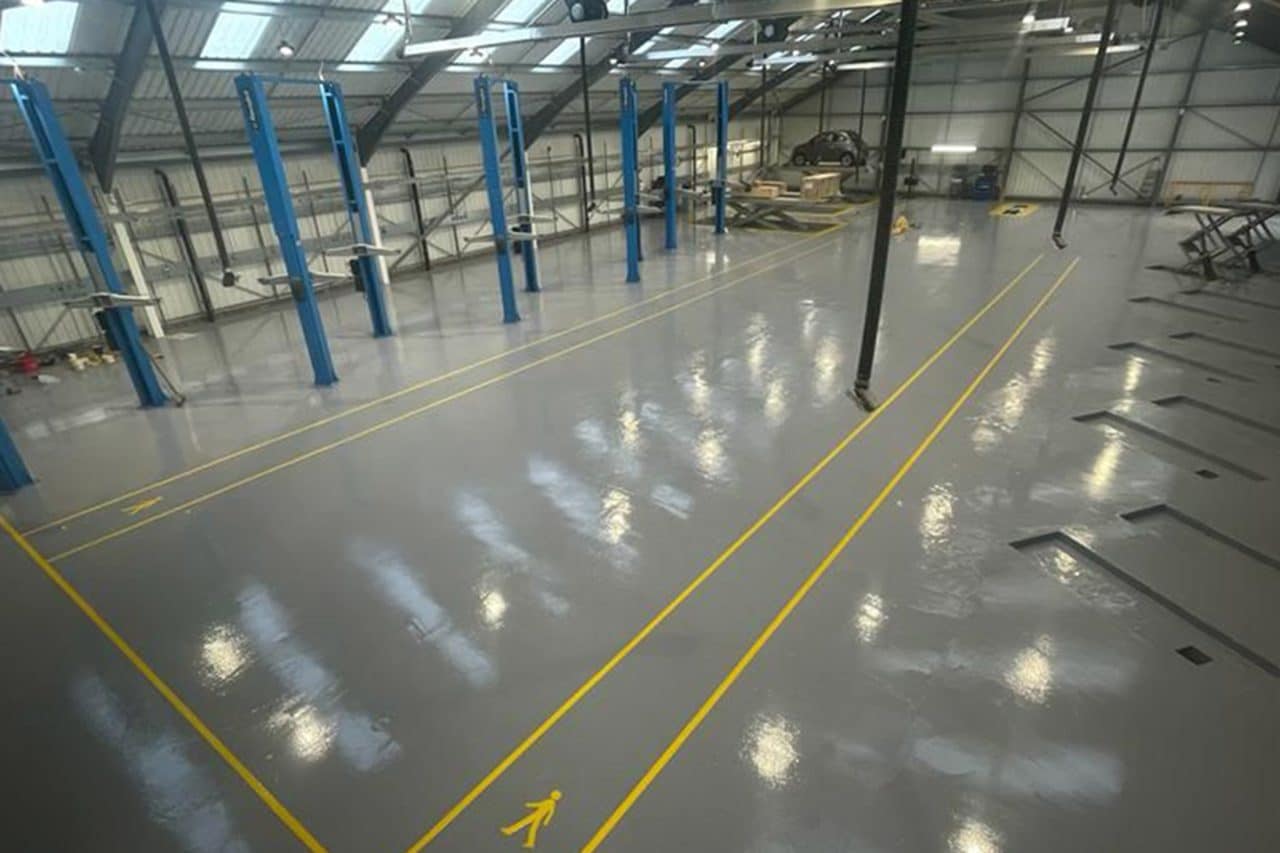 Large MOT service garage in Northampton with grey resin flooring and yellow walkway markings