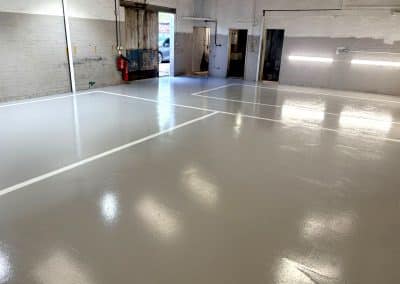 New mid grey epoxy resin flooring, with line markings, at automotive workshop