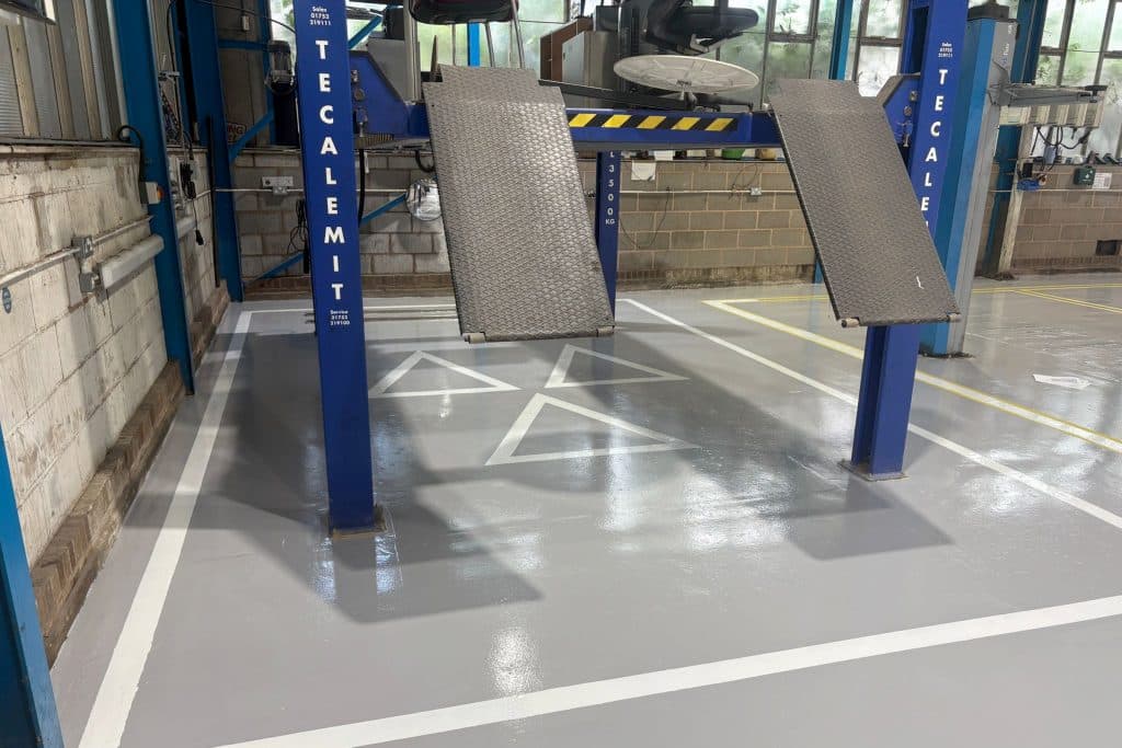 Clean, epoxy resin MOT service garage floor with MOT symbol line markings