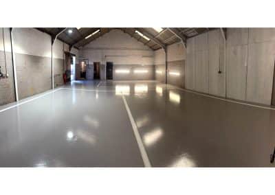 New mid grey epoxy resin flooring, with line markings, at automotive workshop