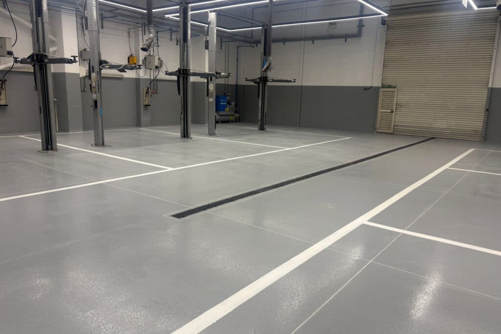 Empty auto workshop with new epoxy resin floor and fresh line marking