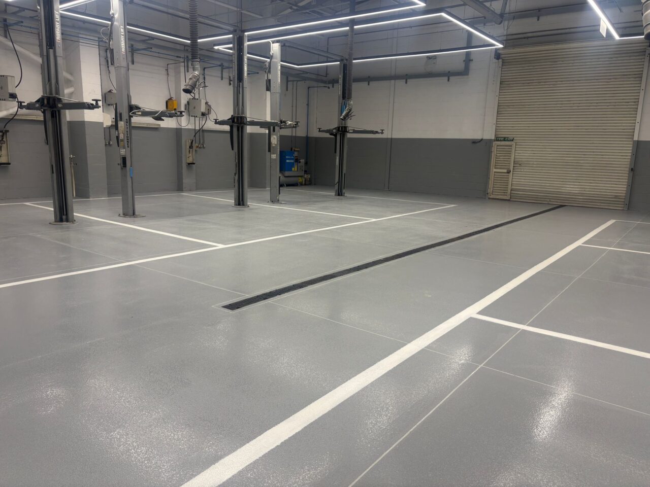 Freshly installed yellow and black resin line marking at an mot test centre in northampton.