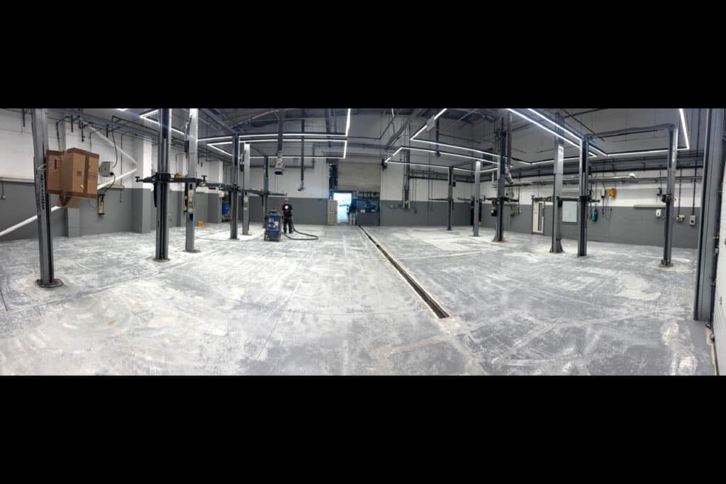 Floor preparation at a workshop with vehicle lifts.