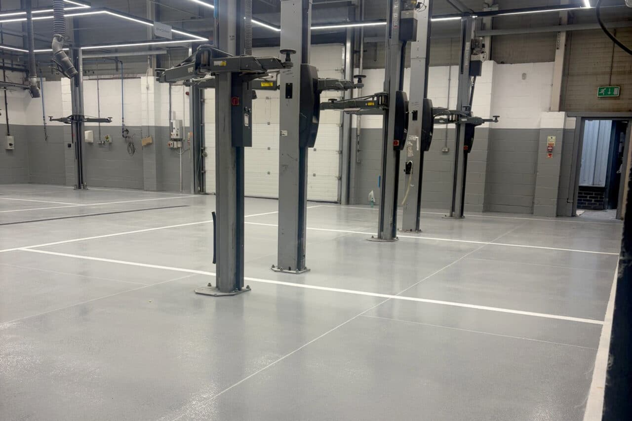 Auto workshop with grey epoxy flooring and white line markings